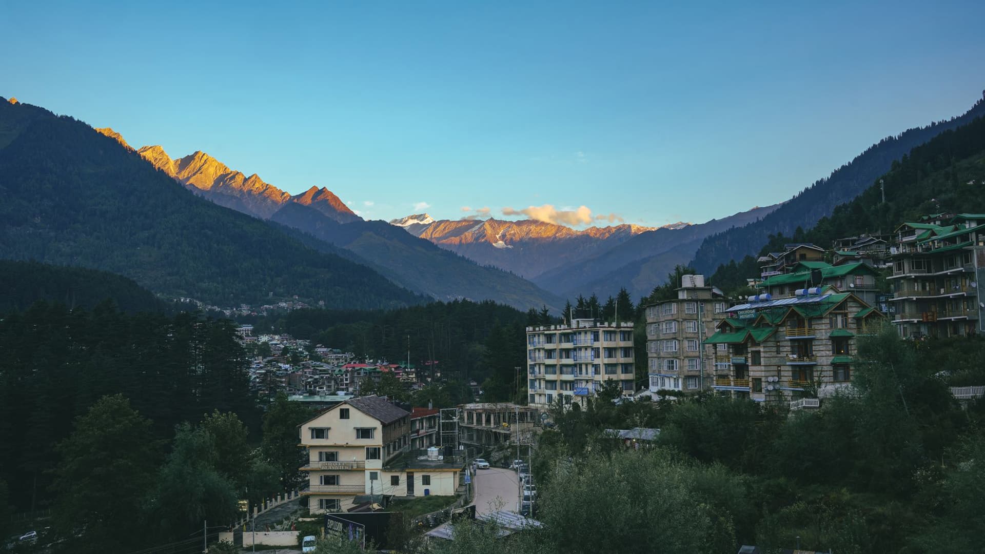 Sunrise lighting up snow-capped Himalayan peaks above the town of Manali